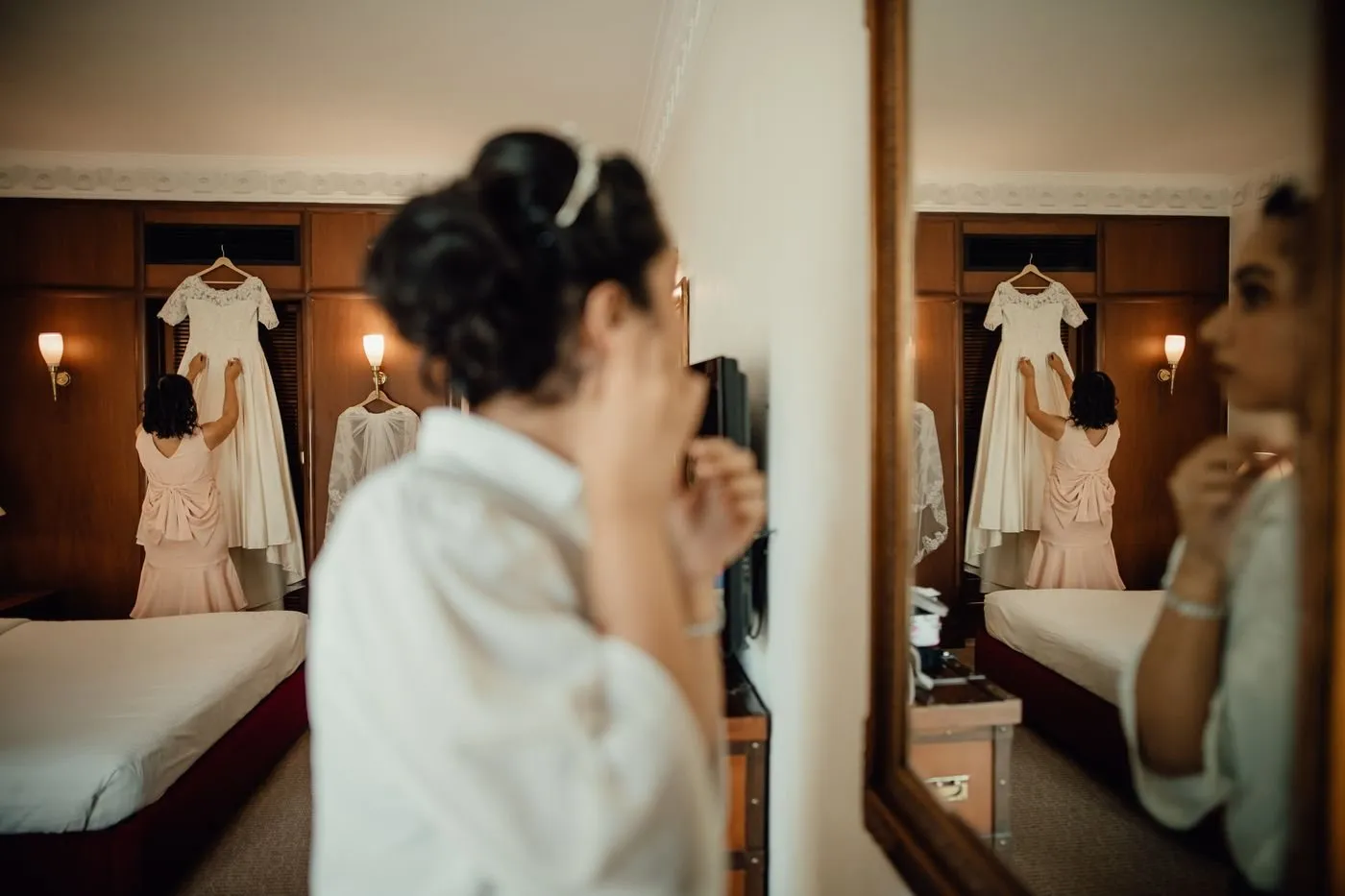 Woman getting ready in front of a hotel room mirror
