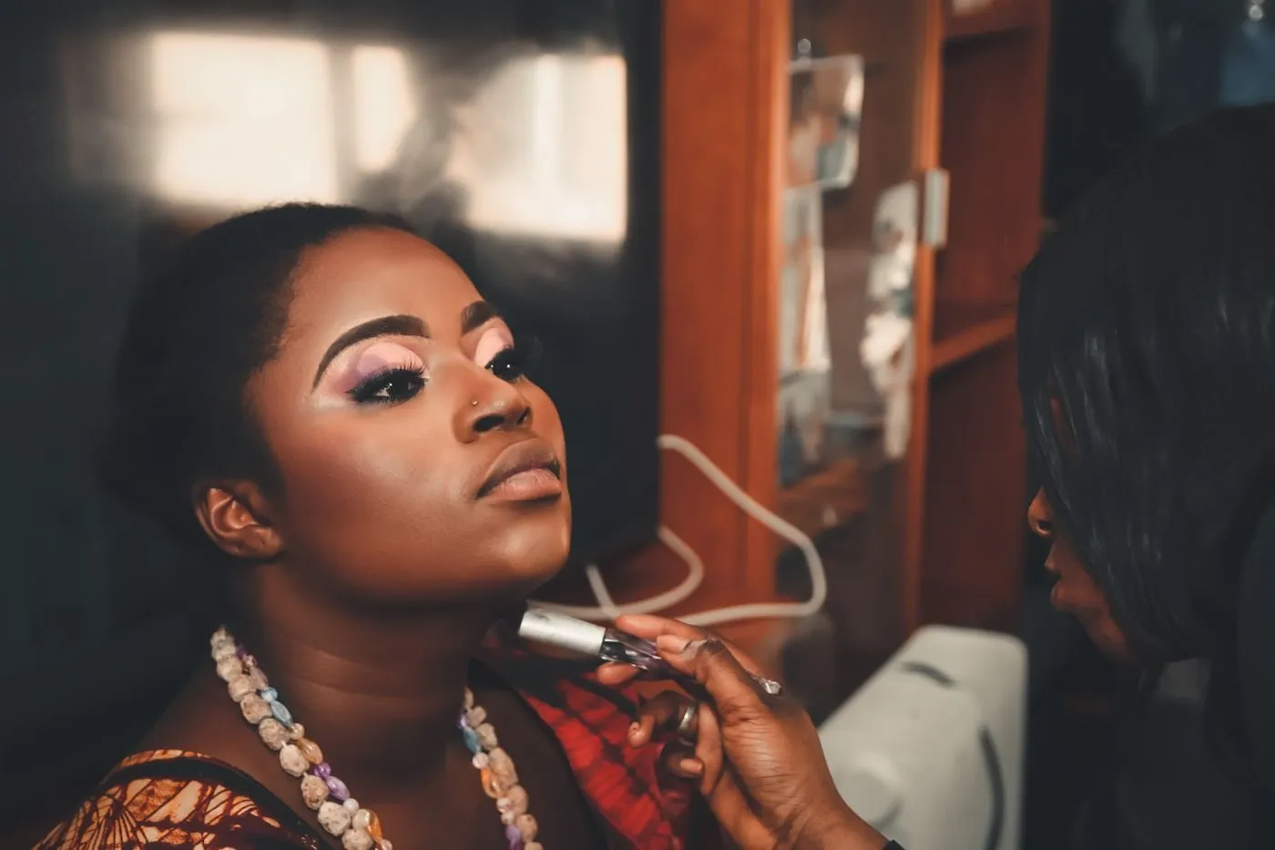 Woman in full glam makeup having lip color applied